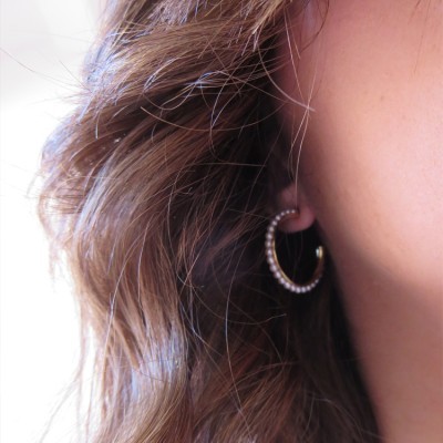 Brinco de argola com pérolas em orelha feminina