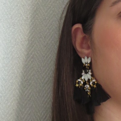 Brinco pendente com detalhes brancos, dourados e pompons pretos