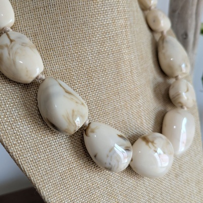 Colar de pedras bege com veios castanhos em suporte bege