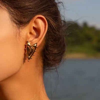 Brinco dourado em forma de coração com detalhes esféricos