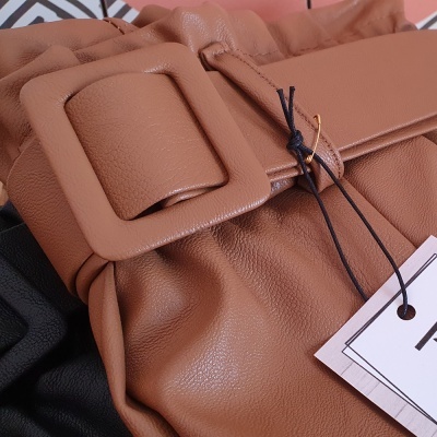 Mala castanha de couro sintético com fivela larga e etiquetas penduradas
