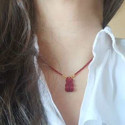 Colar com pendente de ursinho vermelho e cordão vermelho com contas douradas