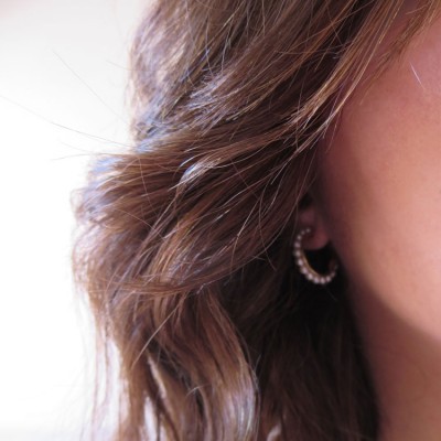 Brinco de argola com pérolas em orelha