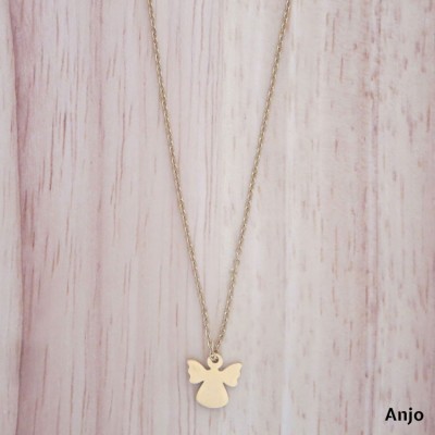 Colar dourado com pendente em forma de anjo sobre fundo claro de madeira.