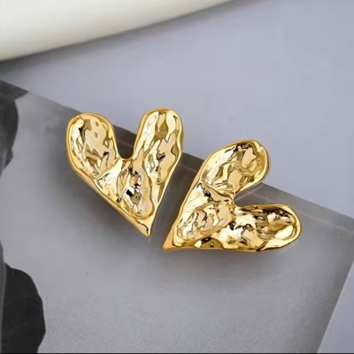 Brincos dourados em forma de coração com textura martelada