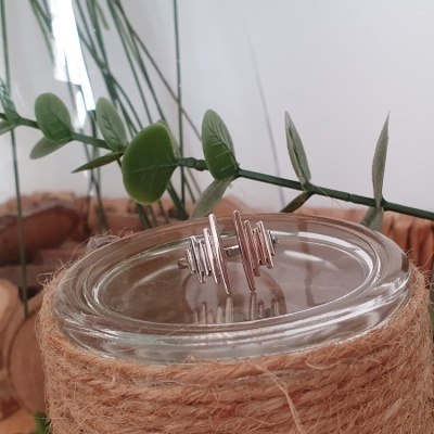 Brincos prateados com design geométrico e tampa de vidro com corda