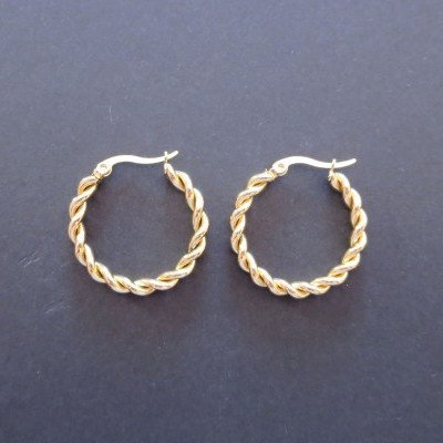 Brincos de argola dourados torcidos sobre fundo preto