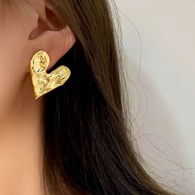 Brinco dourado em forma de coração com textura martelada