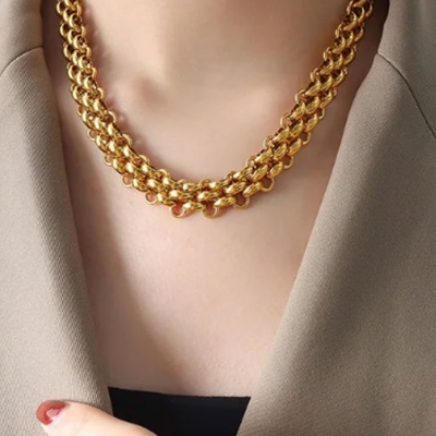 Colar dourado grosso com elos entrelaçados em duas camadas no pescoço
