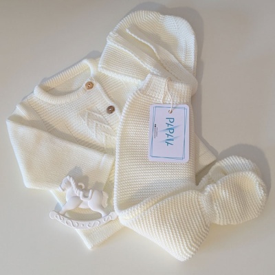 Conjunto de bebé em malha branca com botões, calças, sapatinhos e brinquedo de cavalo de baloiço