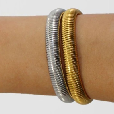 Duas pulseiras metálicas elásticas, uma prata e uma dourada, num pulso