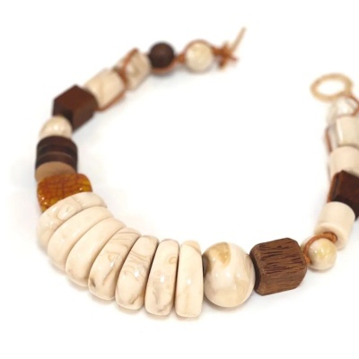 Colar com contas em tons de bege, marfim e castanho sobre fundo branco