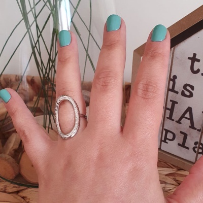Mão com anel prateado oval e unhas pintadas de verde água