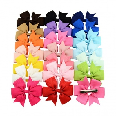 Presilhas de cabelo coloridas em forma de laço organizadas em filas sobre fundo branco