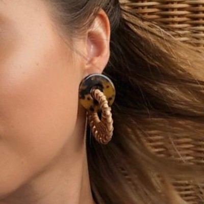 Brinco com padrão tartaruga e anel entrelaçado castanho claro na orelha de mulher