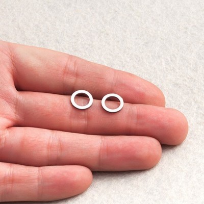 Par de argolas pequenas em metal prateado na mão