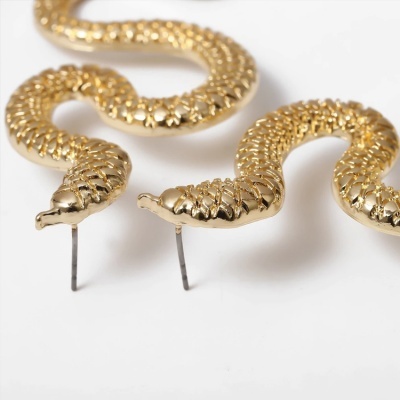 Brincos dourados em forma de serpente com textura escamada