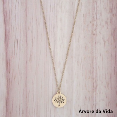 Colar dourado com pendente redondo Árvore da Vida sobre fundo de madeira clara