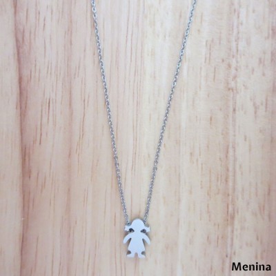 Colar prateado com pendente de boneca em fundo de madeira