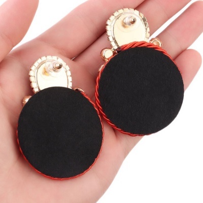 Brincos grandes redondos pretos com borda vermelha e detalhe dourado