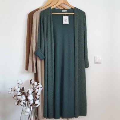 Cardigans de malha verde, bege e castanho pendurados com etiqueta 'ANGEL' e jarra com algodão em botão