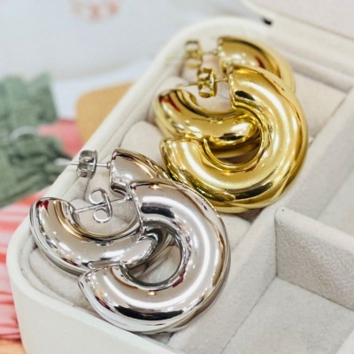 Brincos grossos dourados e prateados em caixa de veludo branco