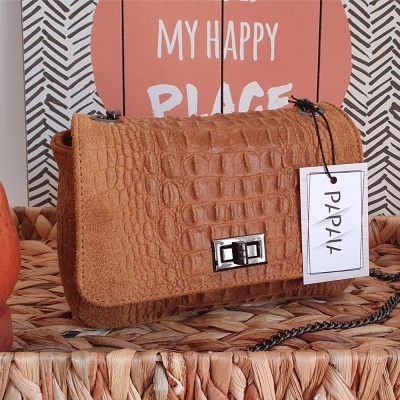Mala castanha em padrão crocodilo com etiqueta PAPAIK sobre vime e cartaz MY HAPPY PLACE