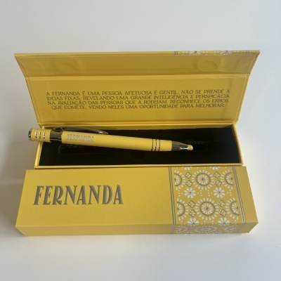 Caneta amarela na caixa amarela com padrão branco e texto Fernanda