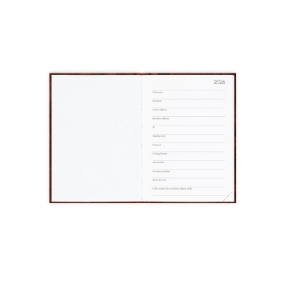 Caderno ou agenda aberto com capa castanha e página de preenchimento para o ano 2026.