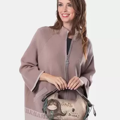 Mulher com casaco bege segurando mala com ilustração e texto