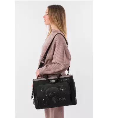 Mala preta de tecido com desenhos e texto, usada por mulher com camisola de malha