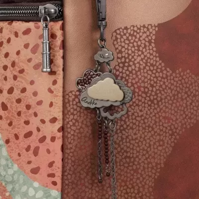 Bolsa castanha com padrão de bolinhas e pendente decorativo de nuvens