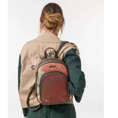 Mochila castanha texturizada com padrões coloridos numa pessoa com casaco bege e verde