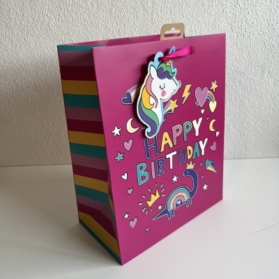 Sacola de presente rosa com ilustração de unicórnio e texto HAPPY BIRTHDAY