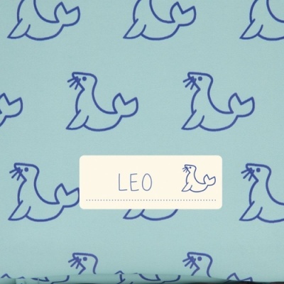 Pano azul claro com padrão de focas azuis e etiqueta com texto LEO