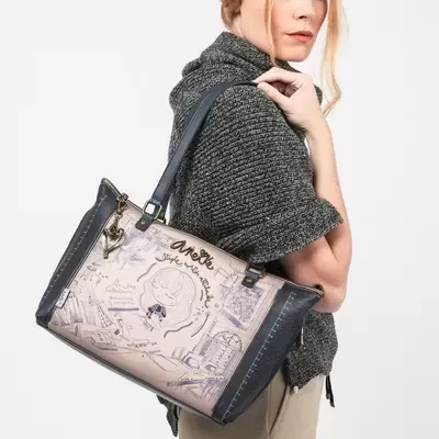 Mulher com mala Anekke Style preta e bege decorada com desenho e texto