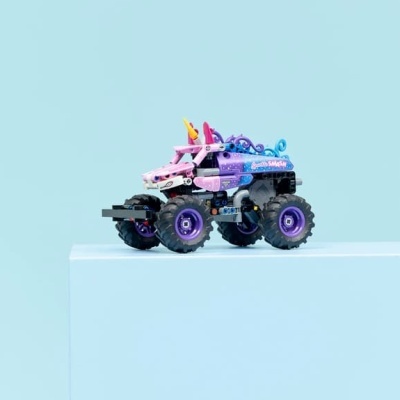 Veículo de brinquedo monster truck colorido em superfície azul clara