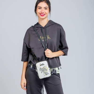 Mulher com hoodie e calças pretas e bolsa branca com texto preto e amarelo