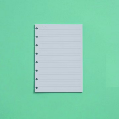 Bloco de papel branco com linhas azuis sobre fundo verde