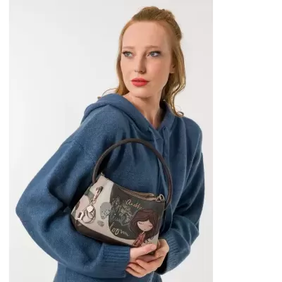 Mala de mão castanha e bege com ilustração e texto Anekke London, segurada por mulher de camisola azul com capuz