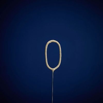 Aro metálico dourado oval em haste fina contra fundo azul escuro