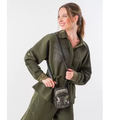 Mulher com camisa e calças verdes-oliva e pequena mala preta
