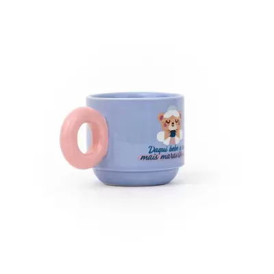 Caneca azul com asa rosa em forma de anel e ilustração de urso com texto