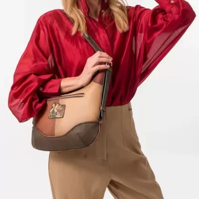 Bolsa castanha com padrão decorativo usada com blusa vermelha e calças bege