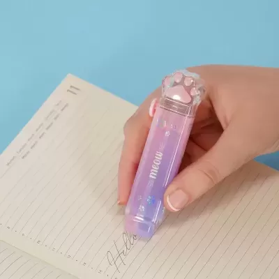 Borracha colorida em formato de pata de gato sendo usada em caderno aberto