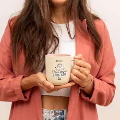 Caneca de cerâmica creme com interior rosa e desenho de unicórnios com texto em português