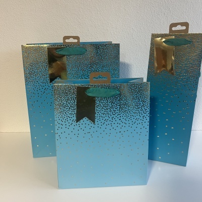 Três sacos de presente azuis e dourados com padrão de estrelas