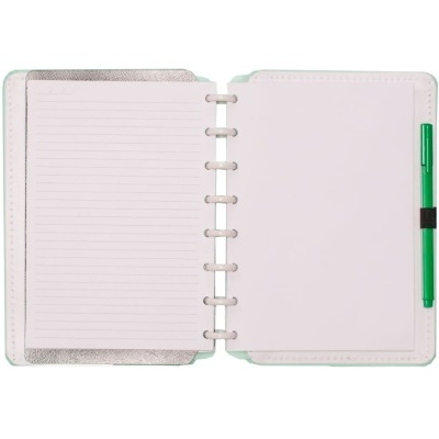Caderno aberto com espiral, folhas pautadas e caneta verde