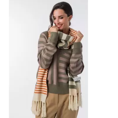 Mulher com camisola de riscas verdes e rosa e cachecol riscas creme, verde e laranja com franjas