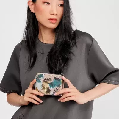 Mulher segurando carteira pequena com padrão colorido